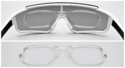 Close-up of a pair of eyeglasses with a white frame on a light gray background.